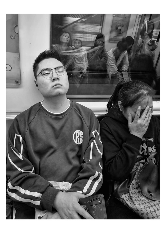一张黑白照片 一个男子坐在地铁上
