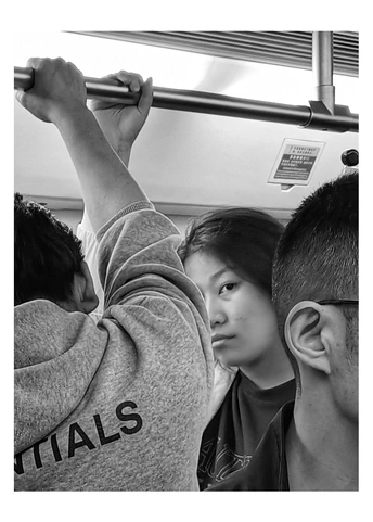 年轻人坐在火车或公共汽车上 男孩倒挂在他们头上。