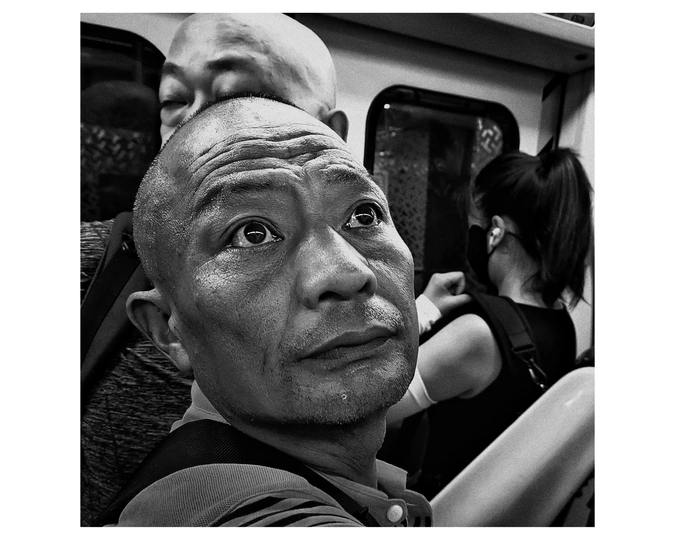 一张黑白照片 一个男子在火车上看着相机