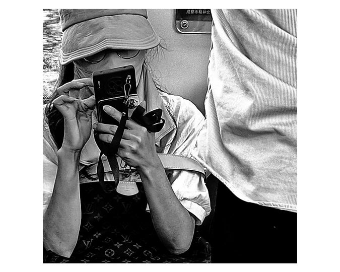 一张黑白照片 一位女士正在给戴帽子的人拍照 他手里拿着相机。