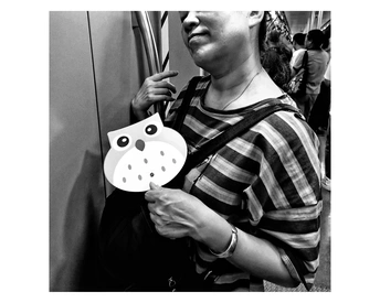 一位年轻女子手持剪刀和面具挡在脸前