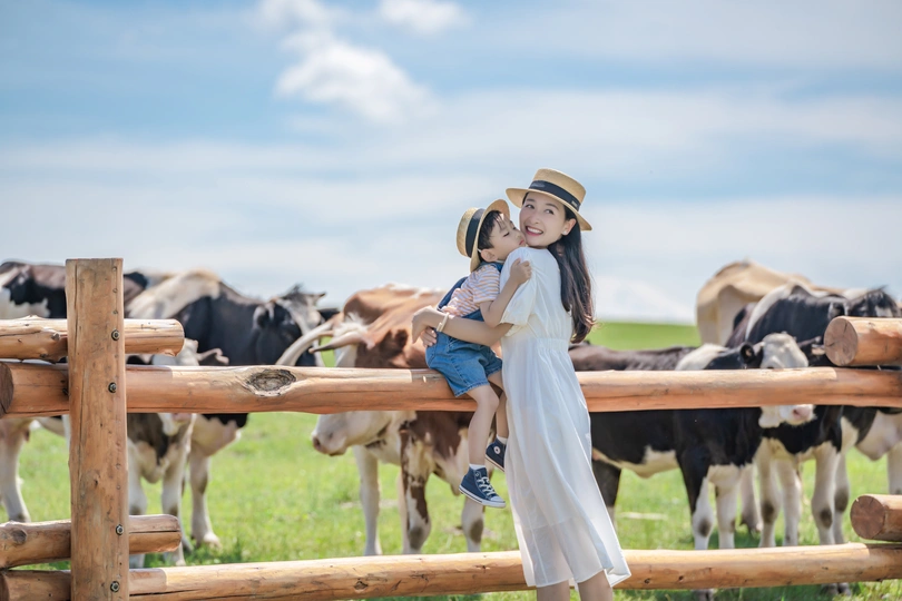 牛场里 一个年轻女孩抱着一个拥抱木栅栏的小女孩