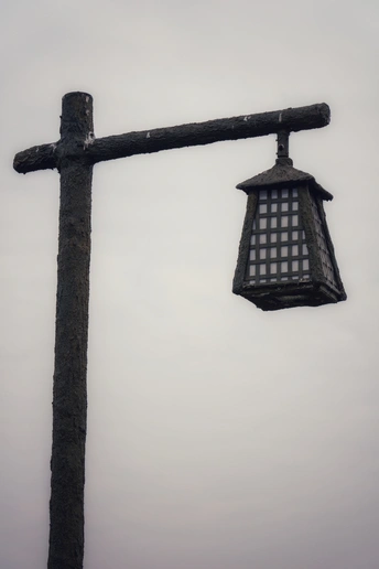 路灯上挂着一个古老的灯笼 顶部有一个木十字架。