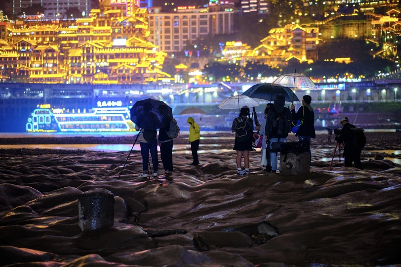 晚上撑着雨伞的人站在海滩上