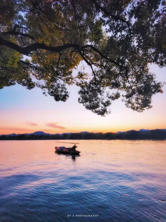 一个小船上的一个人在水下方的树荫下