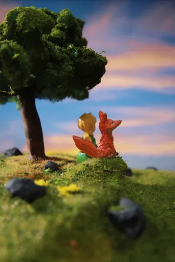 一棵小树和一只红狐狸坐在岩石上