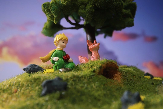 一个坐在树旁的丘陵上的小男孩