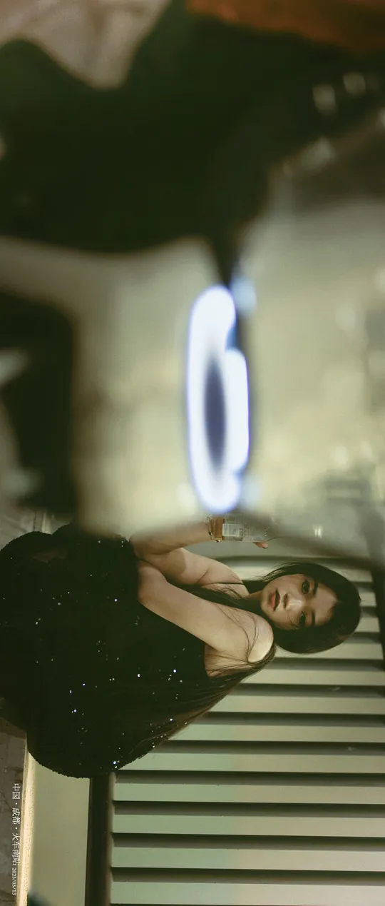 一位穿着连衣裙的女人正在镜子前拍照 拍自己的倒影。