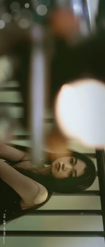 一个年轻女子在灯下照镜子看自己的倒影