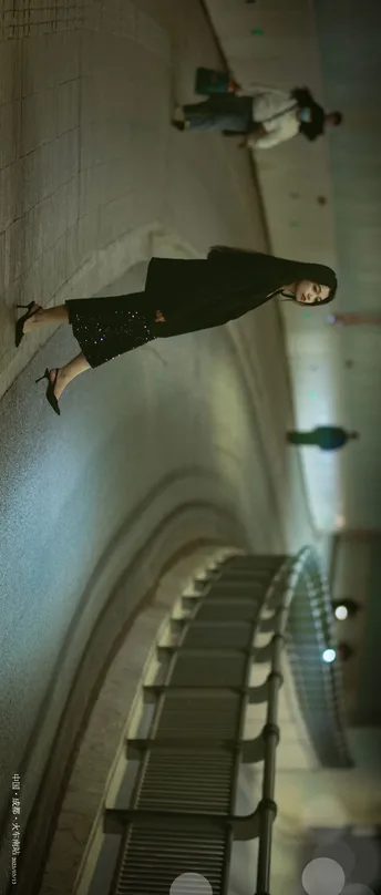 一个站在自动扶梯上的女人拿着一把黑色雨伞