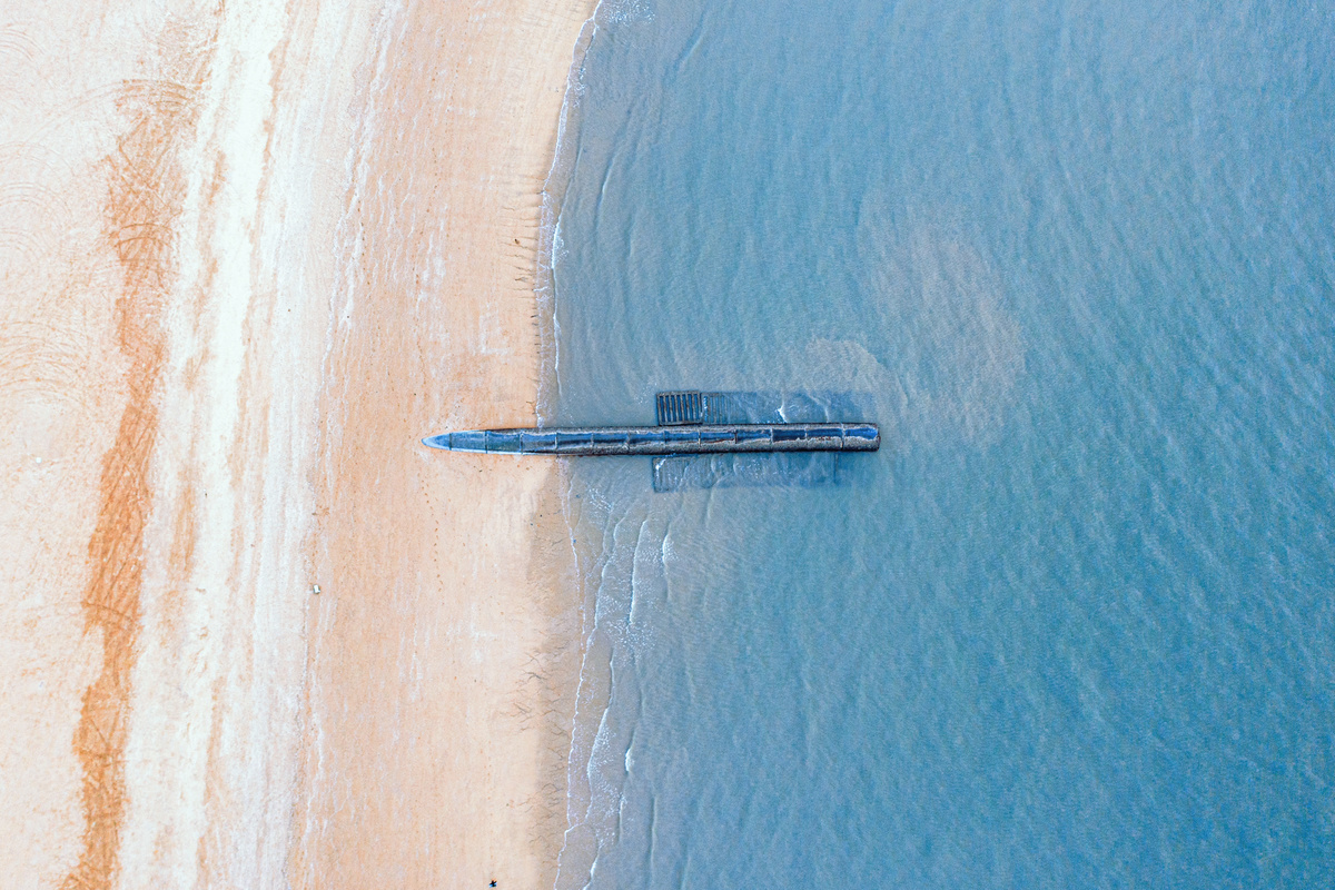 一架漂浮在沙滩上的飞机 周围是蓝色的海水。