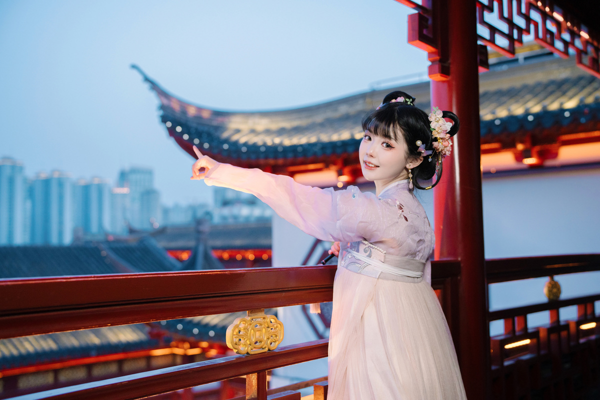 一个穿着中国传统服装的年轻女孩站在阳台上
