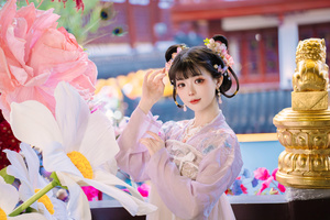 一个穿着传统服装的年轻女孩站在一束花旁边