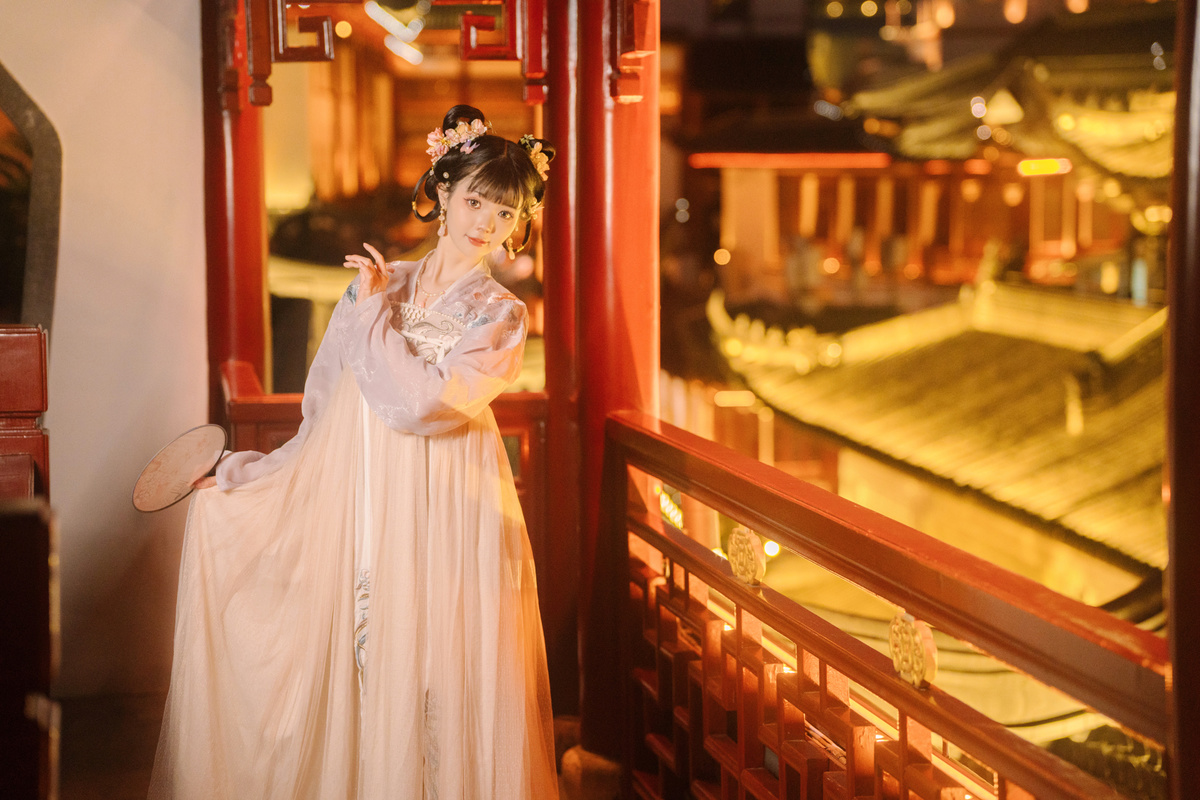 一位穿着白色连衣裙的年轻女子站在一座寺庙里