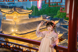 一位穿着传统服装的年轻女子为拍照而站立。