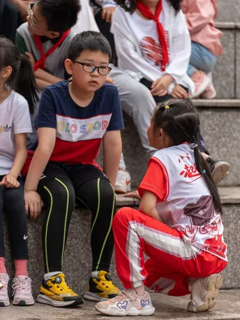 一群年轻人坐在台阶上 还有一个小女孩