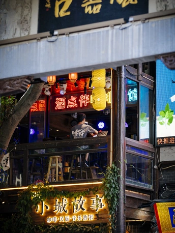 夜晚街道上的霓虹灯和一个男人在酒吧里