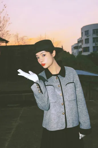 一位戴黑色帽子、外套和手套的女人