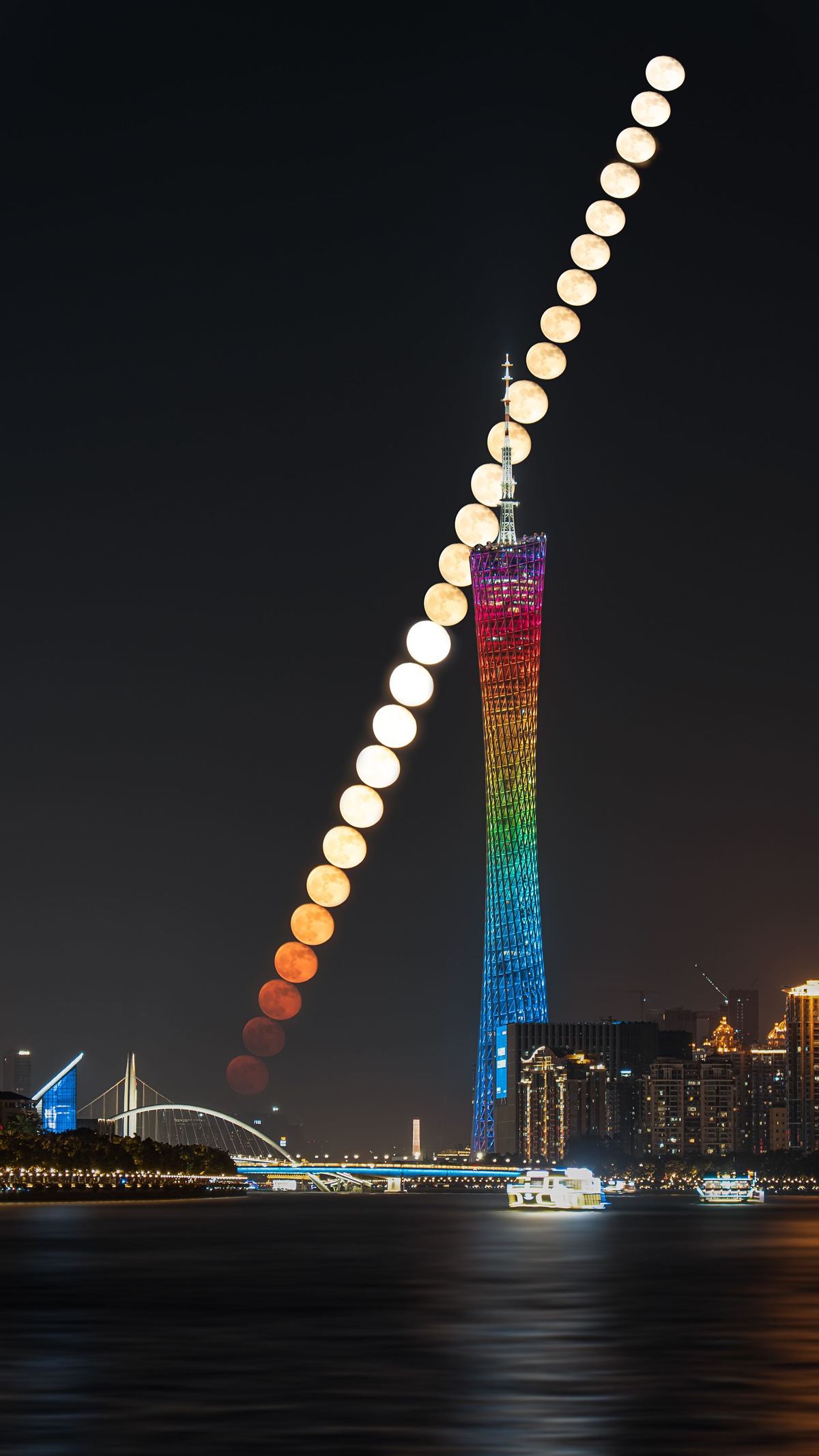 城市夜晚中 一座被不同颜色灯光照亮的高塔。