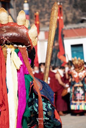 一位穿着传统服装的男子 头戴彩色马 在节日期间沿街行走。