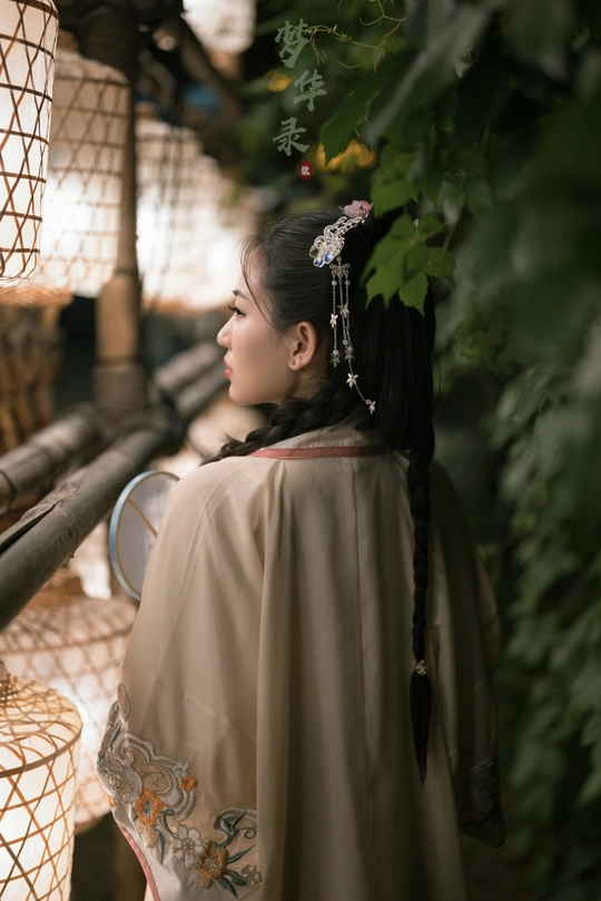 一位穿着日本传统和服的年轻女子站在一个扶手下面。