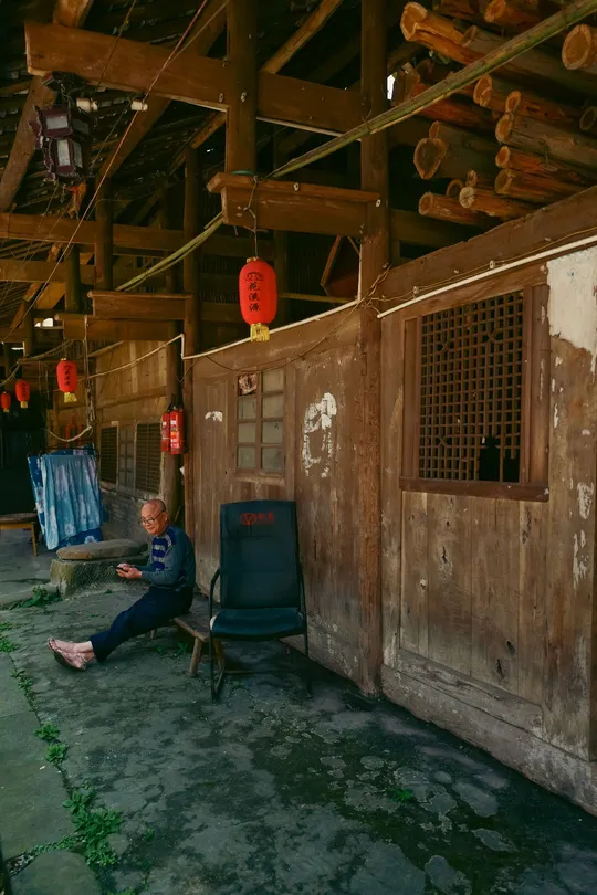 一个坐在老谷仓里椅子上的男人和一个人坐在房间里的女人