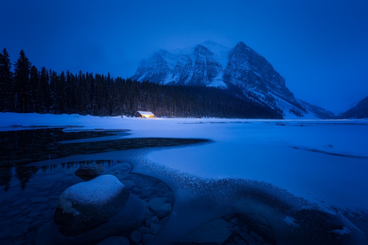 山中的一个冻湖在夜晚被雪照亮了。
