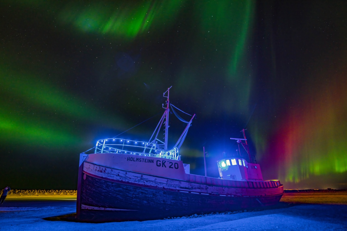 水上的一艘船 天空中出现了北极光