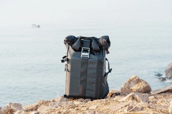 一个黑色的行李袋在俯瞰海洋的陡峭悬崖上