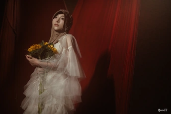 一位穿着白色连衣裙的年轻女子手持一束黄玫瑰 站在红色窗帘前。