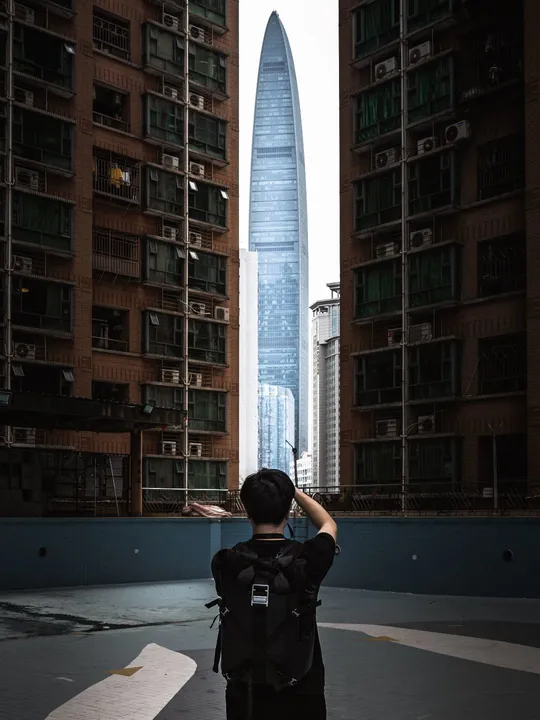 一个人骑自行车在市中心的一座高塔和其他大型建筑之间拍照。