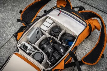 一个橙色的背包里装满了相机