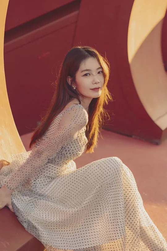 一位年轻美丽的女子穿着红色连衣裙坐在地上