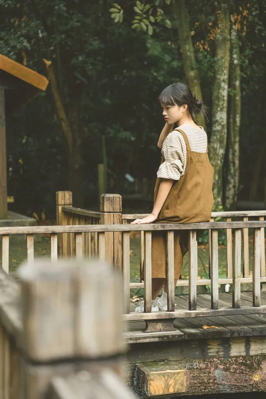 站在水上的木桥上的年轻女子