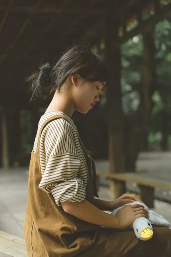 一位年轻女子拿着瓶子和一只坐在香蕉上的鸟