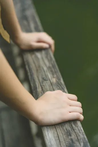 一个小女孩在木桥上握着她的手