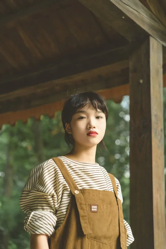 一位穿着工作服和条纹围裙的年轻女子