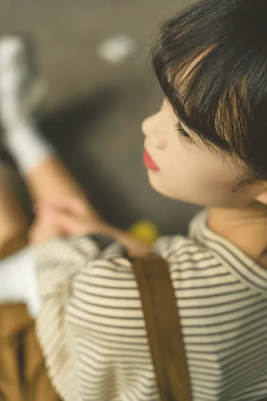 一条纹的小女孩拿着瓶子