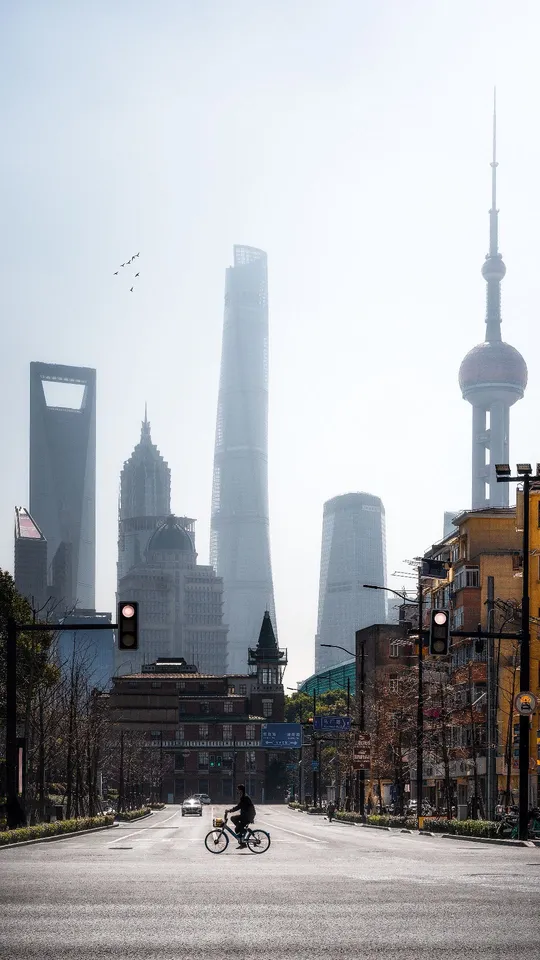 城市中空荡荡的街道 天线上有高楼大厦 一个人骑自行车。
