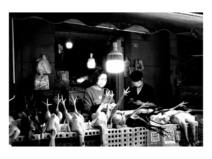 一张黑白照片 人们在市场上 桌子上放着鸟