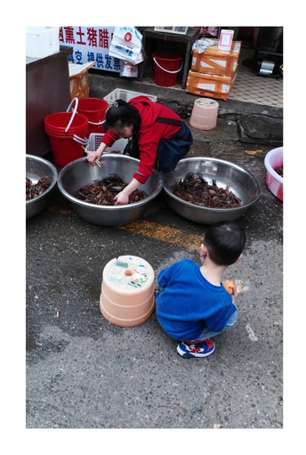 一个小男孩在市场上玩碗里的食物