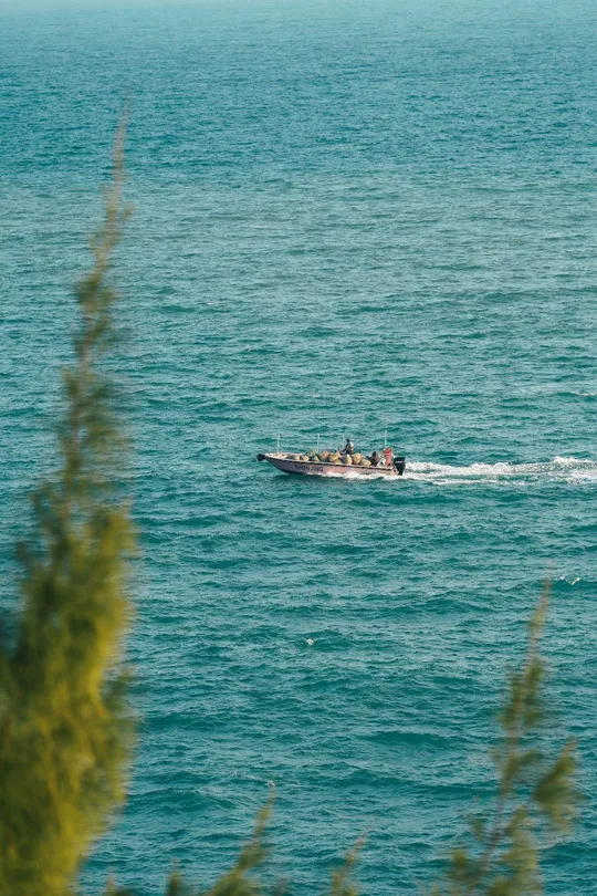 一艘小船在蓝色大海中漂浮 船上有人。