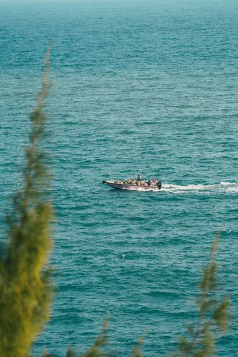 一艘小船在蓝色大海中漂浮 船上有人。