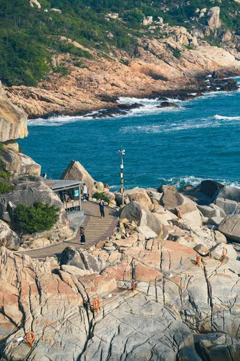 岩石海岸 人们在沙滩上和水里