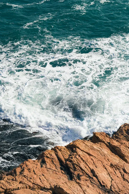 蓝色波浪冲击着海洋岩石海岸