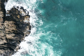 一片翠绿的海域 海浪冲击着海岸边的岩石悬崖