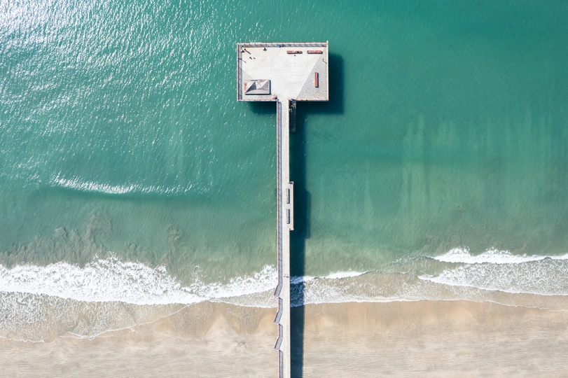 靠近海洋的海滩上的一根杆子上的一个标志