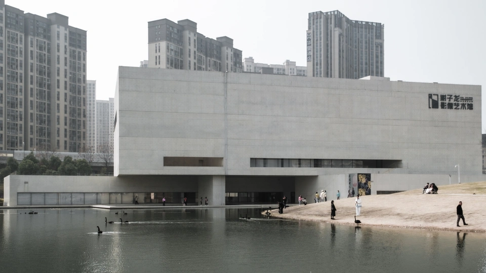 城市中的一个博物馆 前面有一个湖泊 建筑物前面有人们。