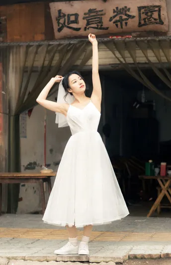 一位穿着白色连衣裙并拿着雨伞的年轻女子