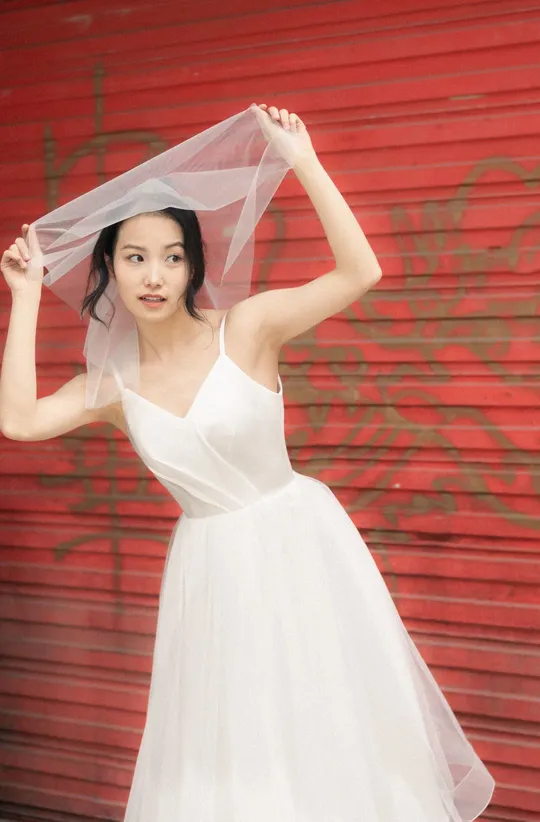 一位穿着白色婚纱头戴面纱的女士